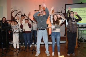 Jugendliche musizieren und bewegen sich in der Kirche.